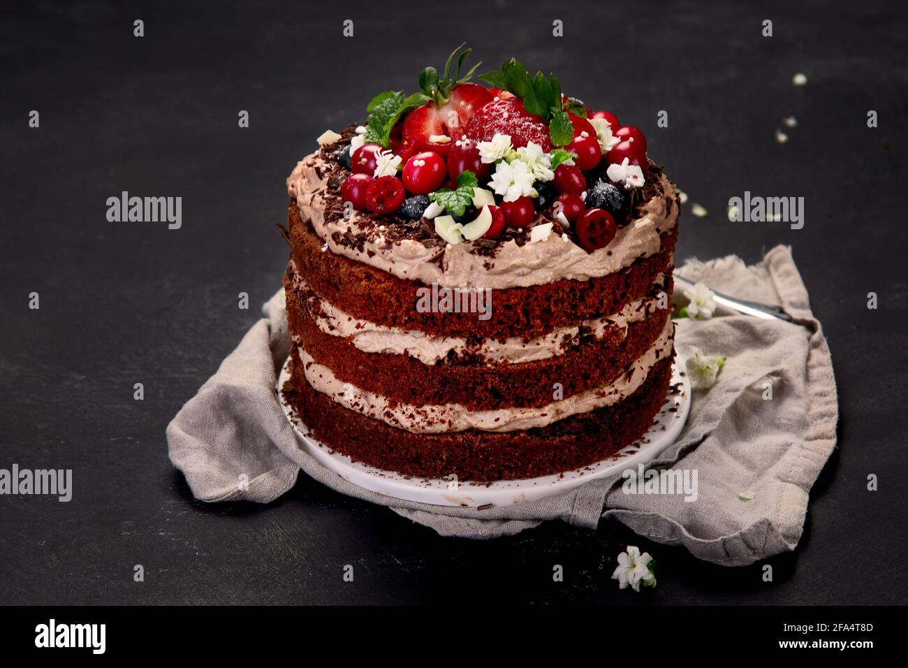 Delicious homemade chocolate cake with fresh berries and mascarpone cream on dark background. Stock Photo