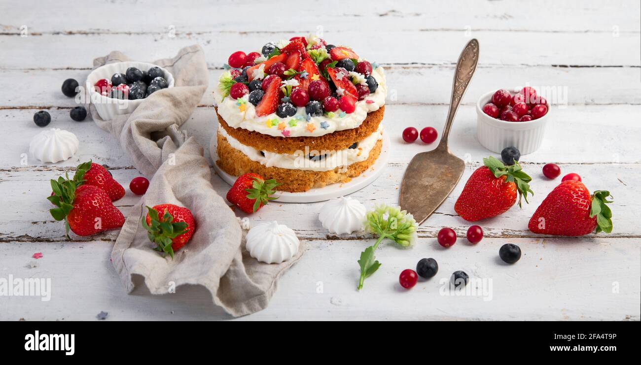 Delicious homemade cake with fresh berries and mascarpone cream on wooden background. Stock Photo