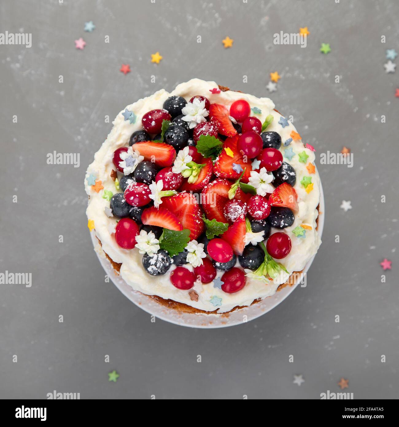 Delicious homemade cake with fresh berries and mascarpone cream on gray background. Top view, copy space Stock Photo