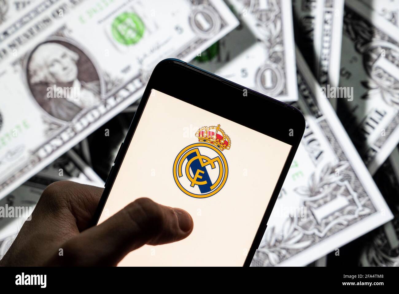 China. 23rd Apr, 2021. In this photo illustration Spanish professional football club team Real Madrid Club de Fútbol commonly known as Real Madrid logo seen on an Android mobile device screen with the currency of the United States dollar icon, $ icon symbol in the background. (Photo by Budrul Chukrut/SOPA Images/Sipa USA) Credit: Sipa USA/Alamy Live News Stock Photo