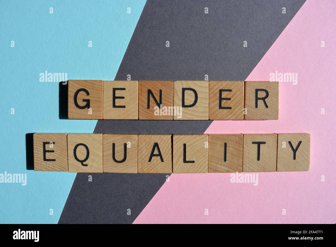Gender Equality, words in wooden alphabet letters isolated on pink, blue and grey background Stock Photo