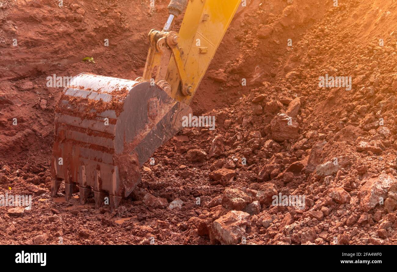 Backhoe working by digging soil at construction site. Bucket of backhoe