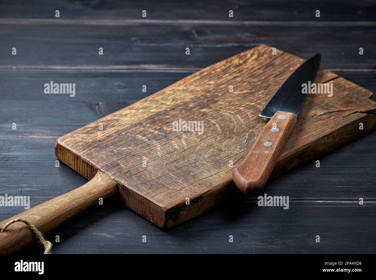 empty wooden cutting board and knife on rustic kitchen table Stock Photo