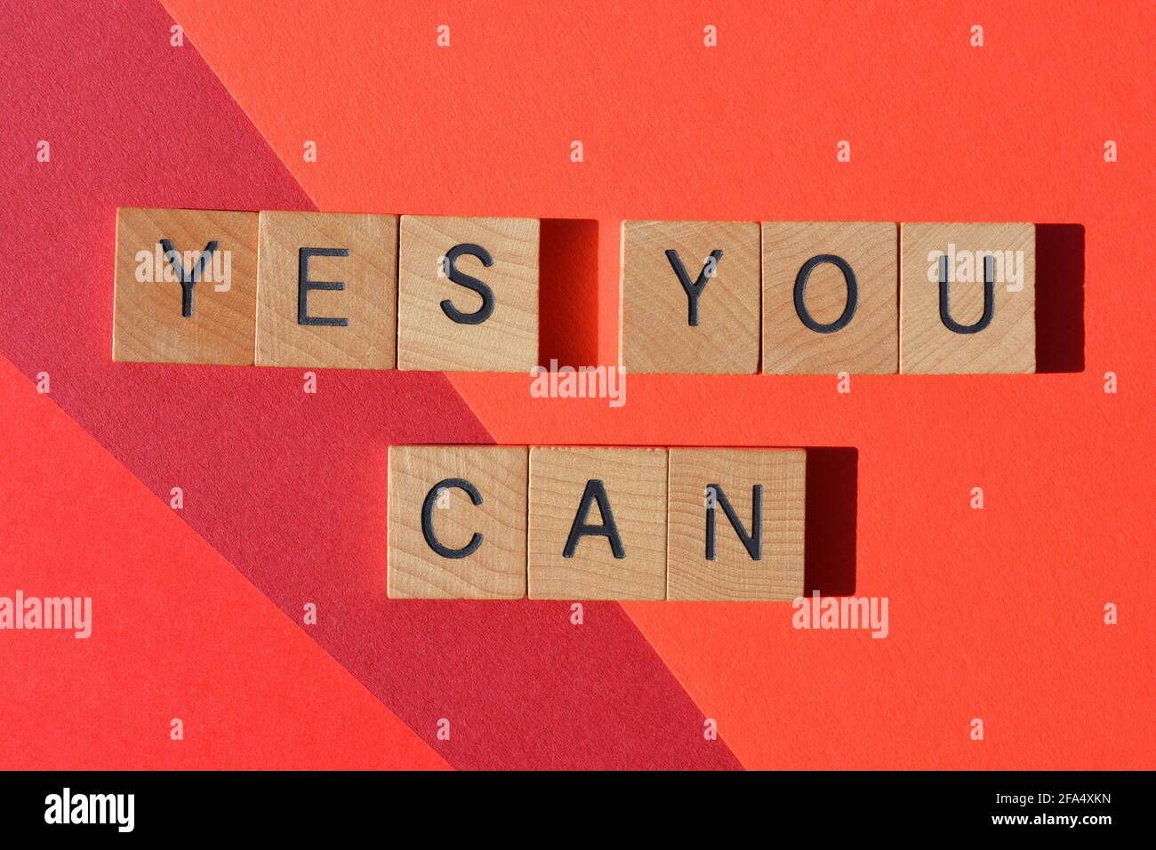 Yes You Can, motivational words in wooden alphabet letters isolated on red background Stock Photo