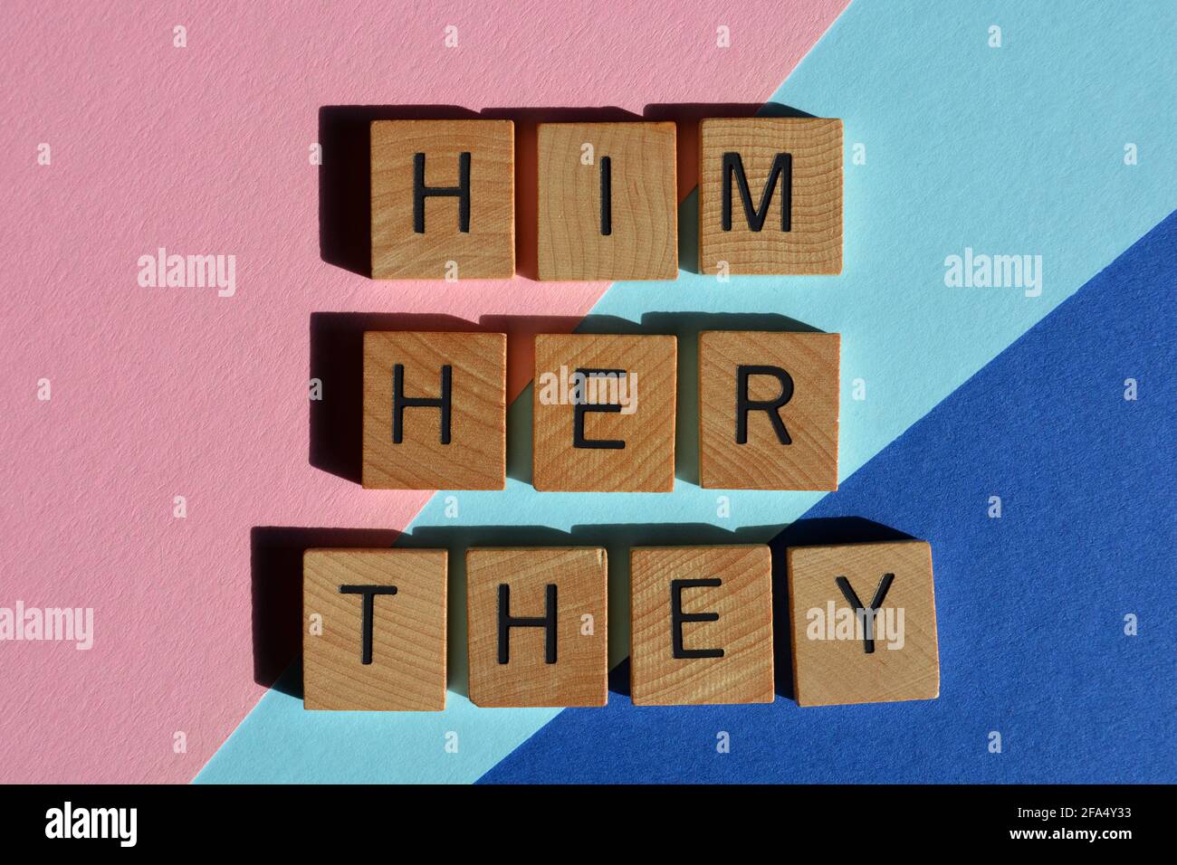 Him, Her, They, gender pronouns on pink and blue background Stock Photo
