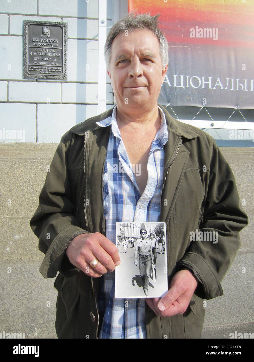 01 April 2021, Ukraine, Kiew: Ilya Suslov holds a photograph of himself in his hands. As a student in 1986, Ilya Suslov travelled from Navoiy in Uzbekistan, 3000 kilometres away, to the damaged Chernobyl nuclear power plant. From mid-August to mid-October, the then 25-year-old worked as a foreman on the construction of the first concrete sarcophagus. After the collapse of the Soviet Union, the now 60-year-old moved to Kiev in the now independent Ukraine and is now a disability pensioner. (to dpa '35 years of Chernobyl: Nuclear accident burdens witnesses and politics') Photo: Andreas Stein/dpa Stock Photo