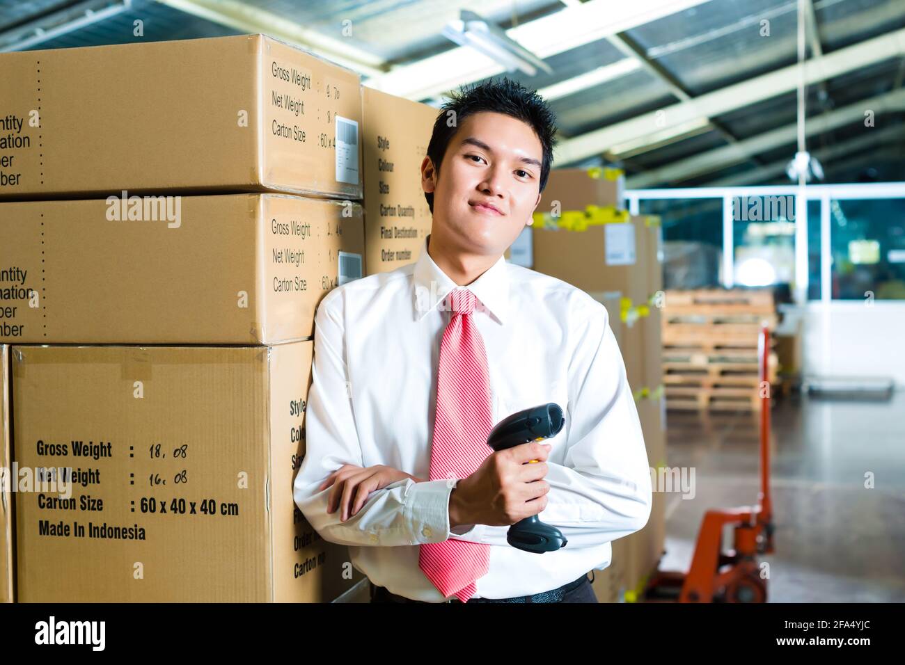 Young man in a suit with a bar code scanner in a warehouse Stock Photo ...