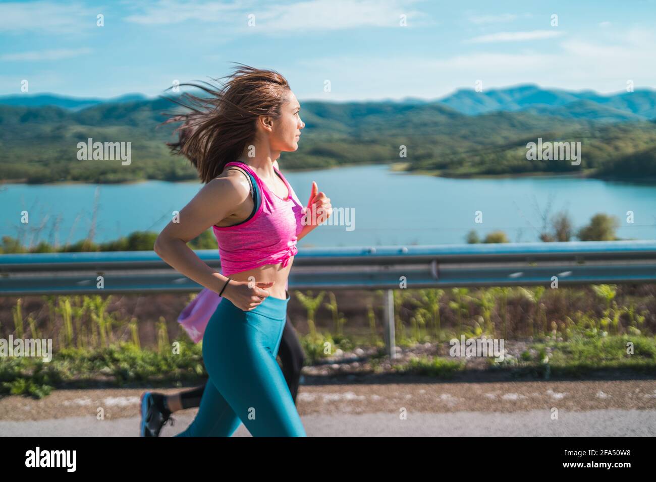 Female fitness models racing each other with beautiful lake background Stock Photo