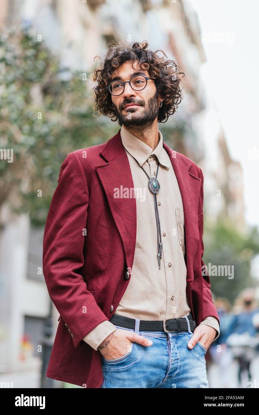 portrait of an attractive caucasian young man standing in the streets of  Barcelona with his hands