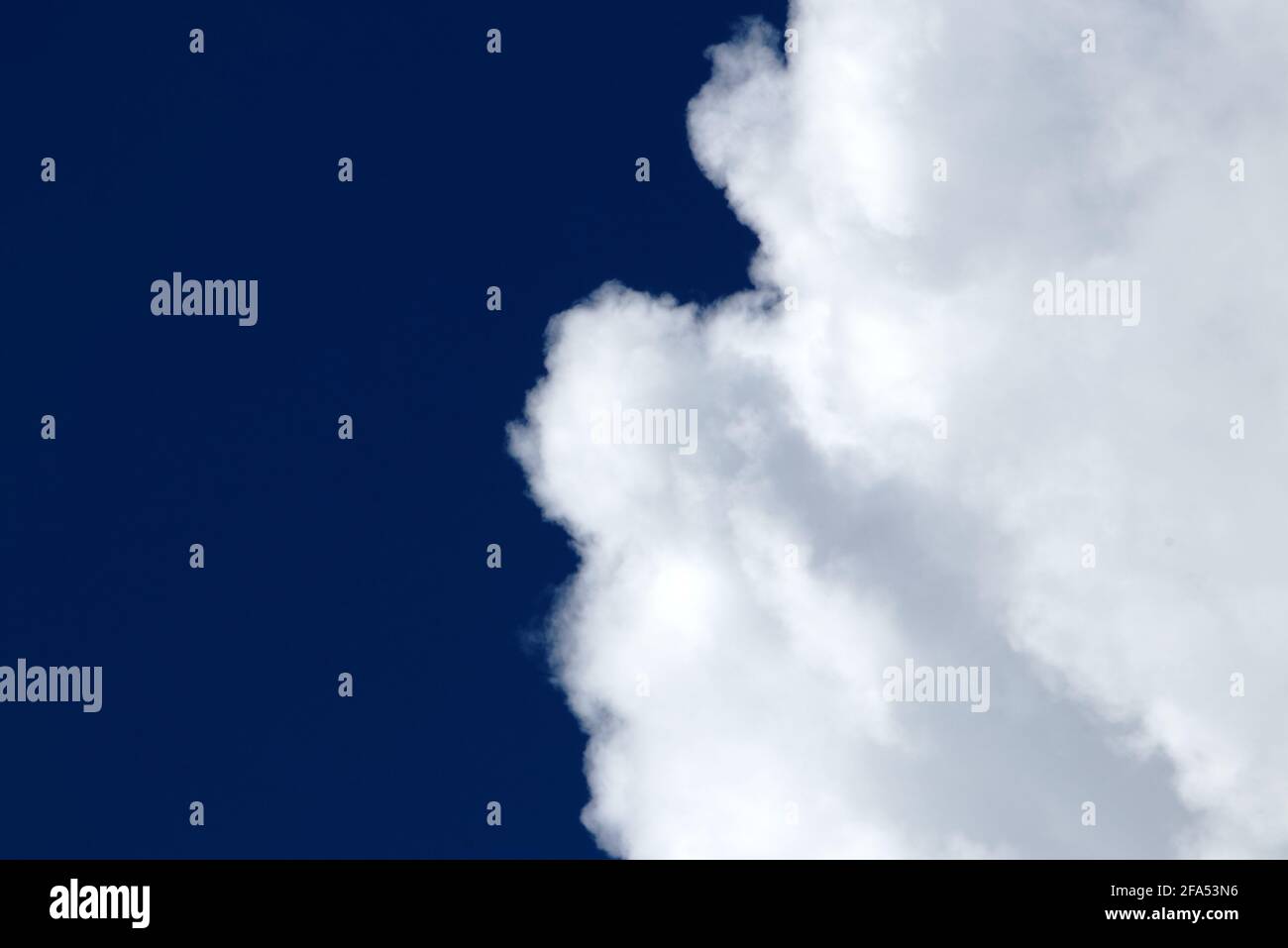 White fluffy clouds on a dark blue sky - cloudscape, overcast - cloudscape background Stock Photo