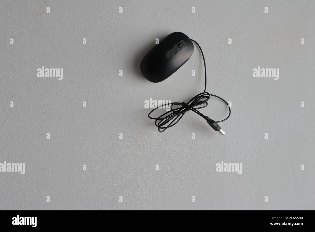 Closeup black minimalist mouse attached to white cement wall Stock Photo