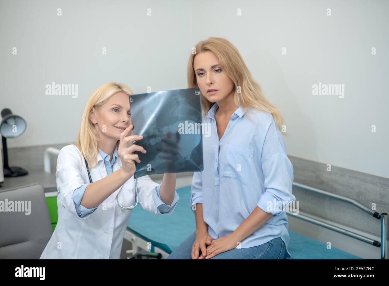 Doctor showing x-ray to interested patient Stock Photo