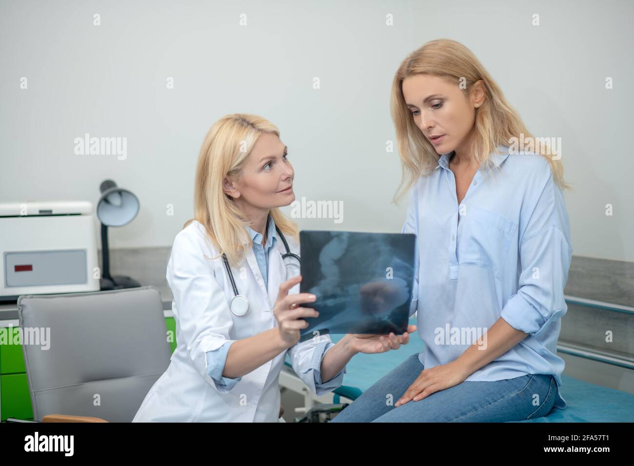 Doctor with x-ray and patient communicating in consultation Stock Photo