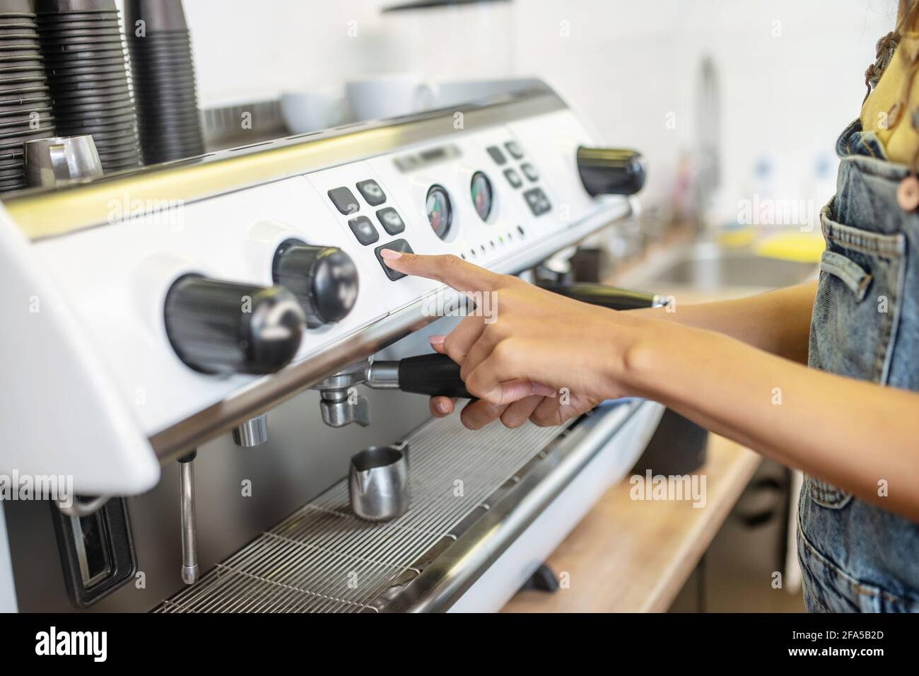 Female hand pressing button on panel of coffeemachine Stock Photo