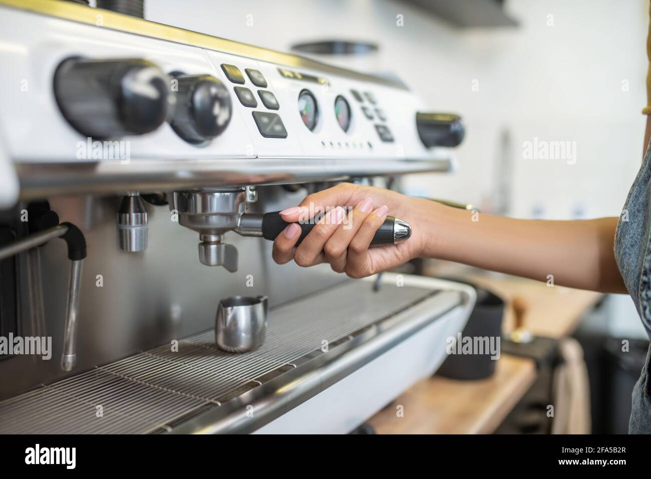 Womans hand holding holder of coffee machine Stock Photo