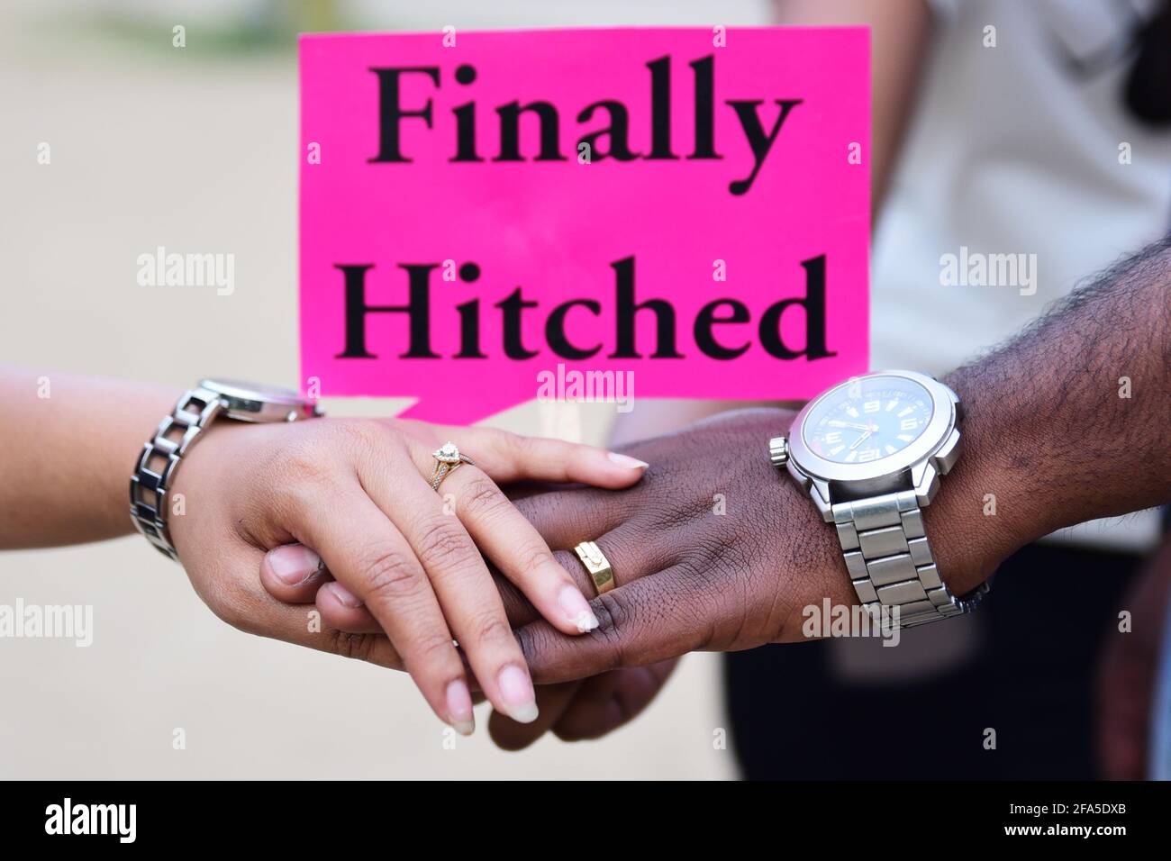 Indian Married Couple holding hands with quote "finally hitched Stock