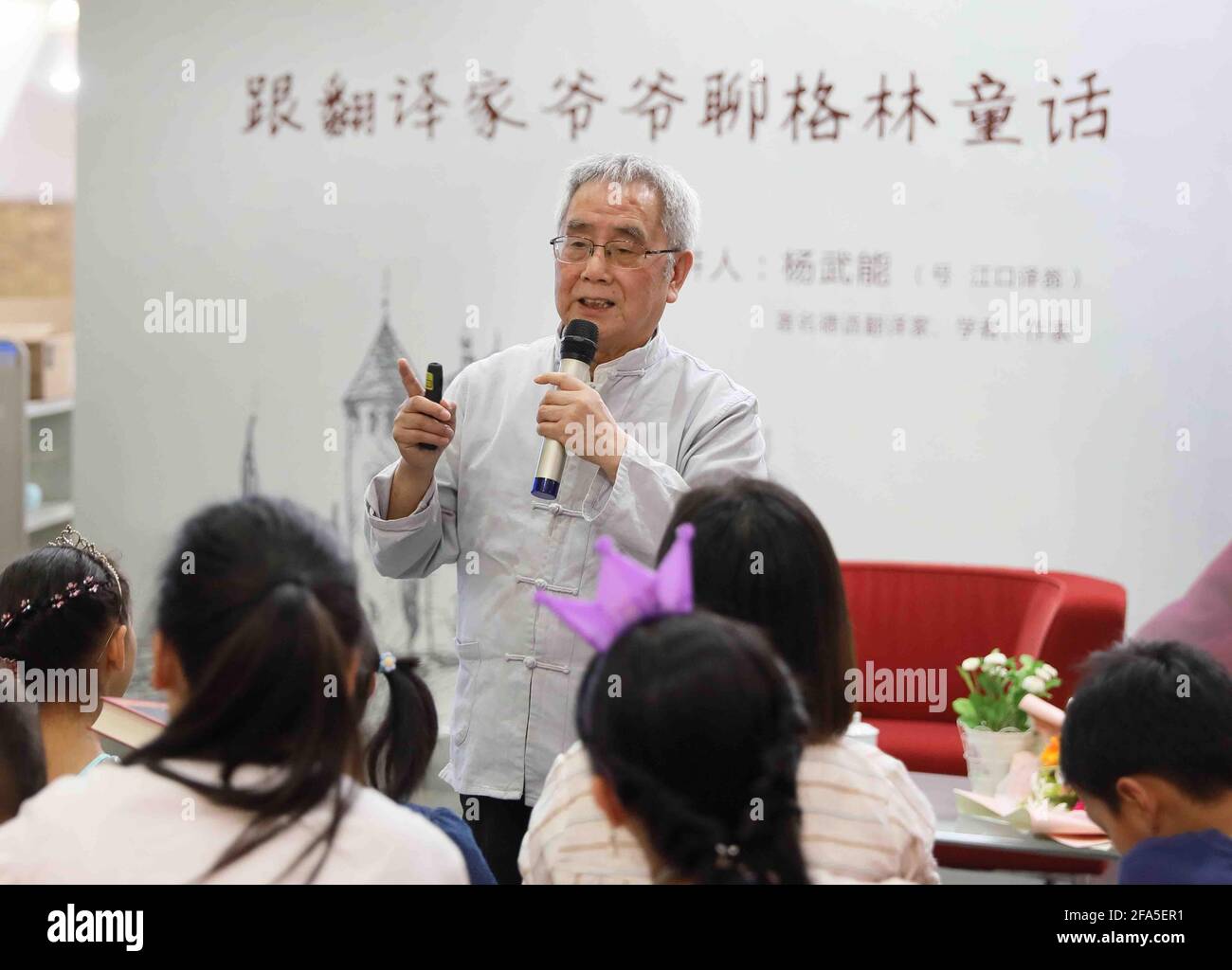 (210423) -- CHENGDU, April 23, 2021 (Xinhua) -- File photo taken in 2018 shows Yang Wuneng meeting young readers at a cultural event on 'Grimms' Fairy Tales' at Chongqing Library in southwest China's Chongqing. In a career that spans over 60 years, Yang Wuneng has translated 31 German classics into the Chinese language, including 'Faust', 'Selected Poems of Heinrich Heine' and 'Immensee.' Many of his translations are still bestselling books in some bookstores. His translation of 'Grimms' Fairy Tales,' for instance, has been popular among Chinese readers for many generations. Today, Yang is sti Stock Photo