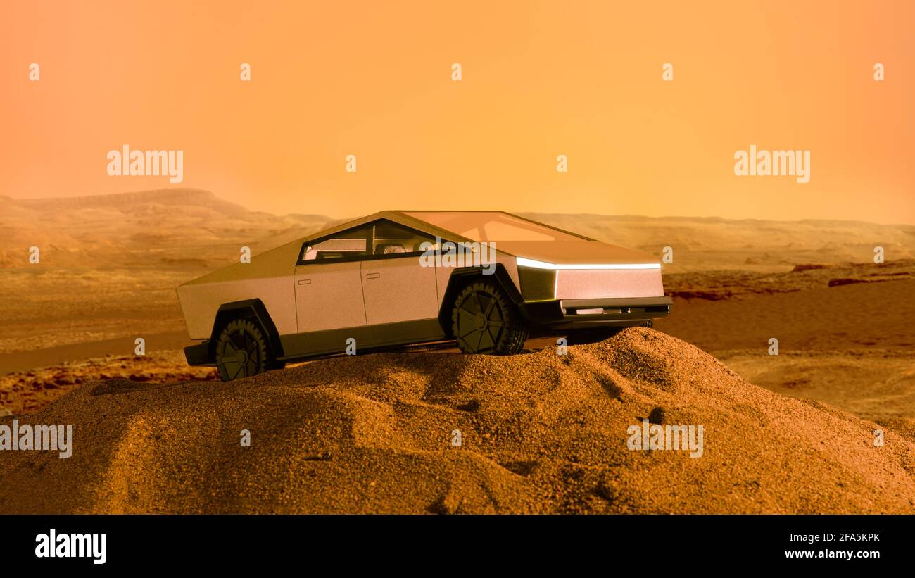 Izmir, Turkey - April 20, 2021: Close up shot Tesla Cybertruck handcrafted model car on sand and with a Mars background which taken from NASA  Backgro Stock Photo