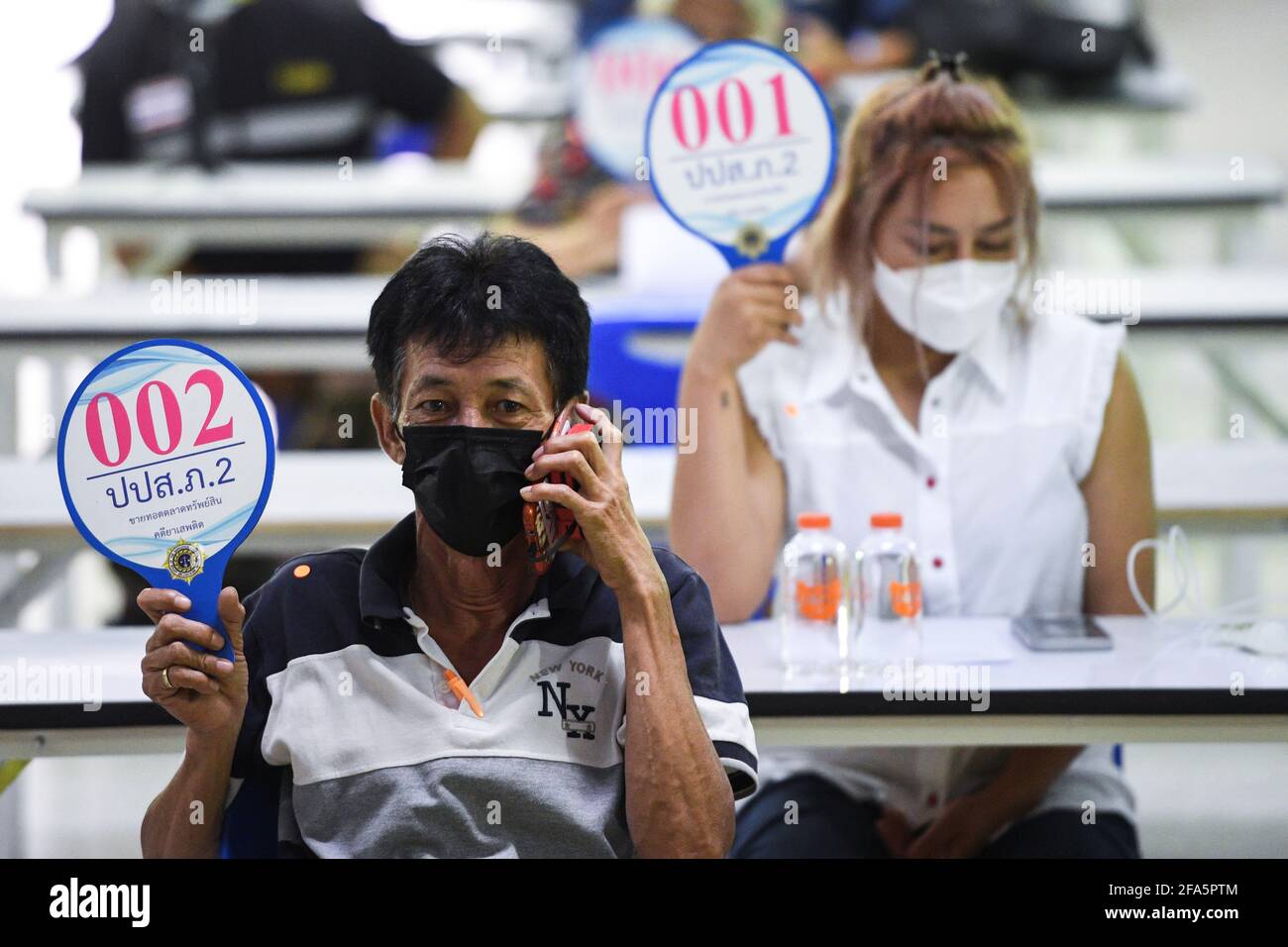 People raise their bidding signs at an auction for pedigree cats which were  confiscated as live assets in a drug bust case in Rayong province, Thailand, April 23, 2021. REUTERS/Chalinee Thirasupa Stock Photo