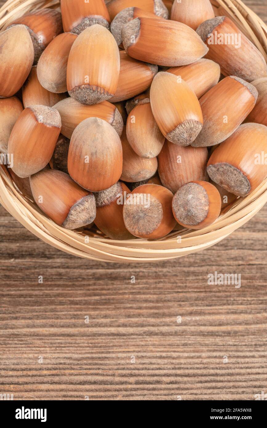 closeup hazelnuts with nutshells in the basket on a wooden table Stock Photo