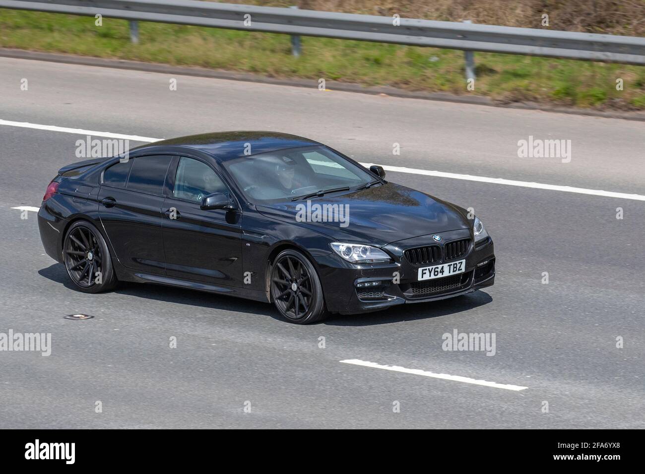 2014 black BMW 640D Sport Gran Coupe; moving vehicles, cars, vehicle driving on UK roads, motors, motoring on the M6 English motorway road network Stock Photo