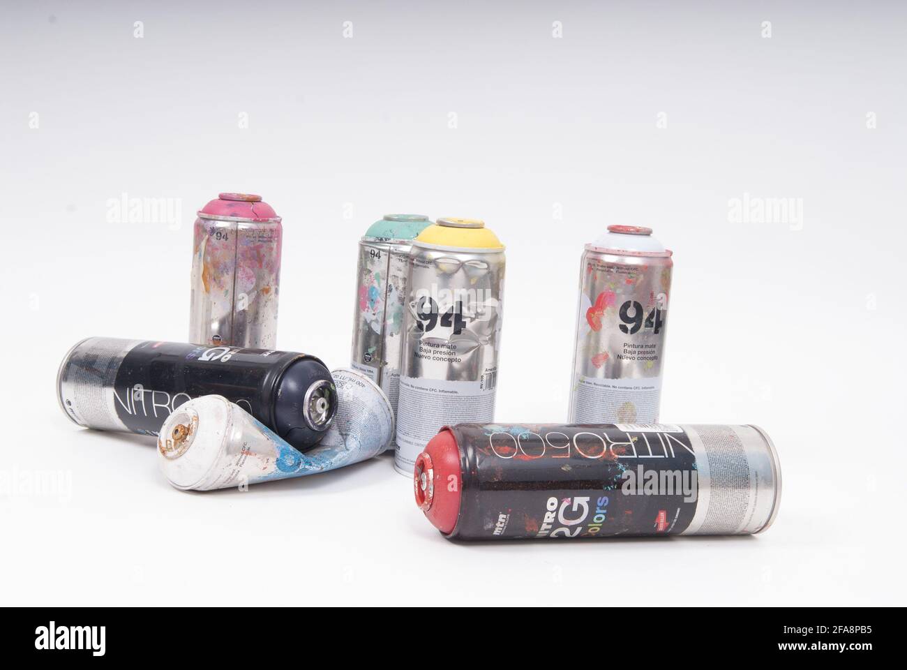AMSTERD, NETHERLANDS - Apr 21, 2021: Empty spray cans standing an laying used by graffiti artists on a white background Stock Photo