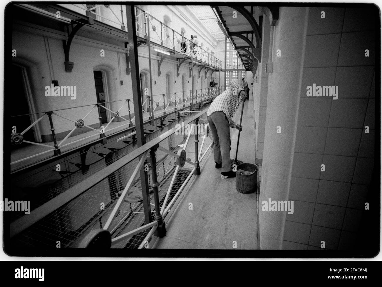Hull Prison July 1990 Scan made in 2021 Cleaning the wing. HM Prison Hull last prison in the UK to have ‘slopping out’. This was the reason that the photographer was allowed in to document. Pictures taken with permission. Hull Prison opened in 1870, and is of a typical Victorian design HMP Hull is a Category B men's local prison located in Kingston upon Hull in the East Riding of Yorkshire, England. The term 'local' means that this prison holds people on remand to the local courts. The prison is operated by Her Majesty's Prison Service. Stock Photo