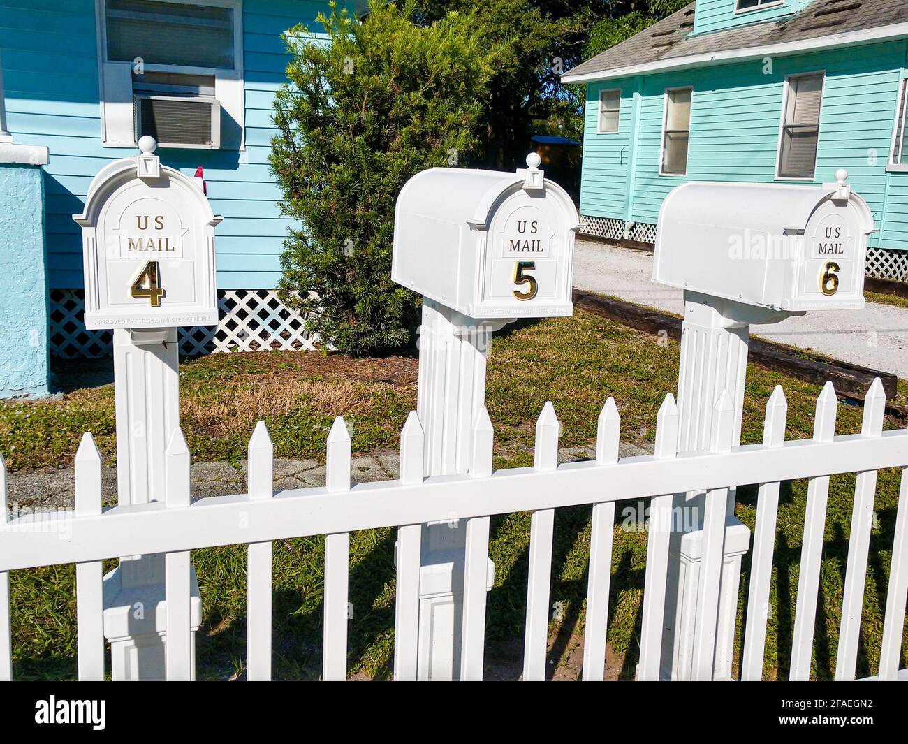 Row of white mailboxes on white picket fence Stock Photo