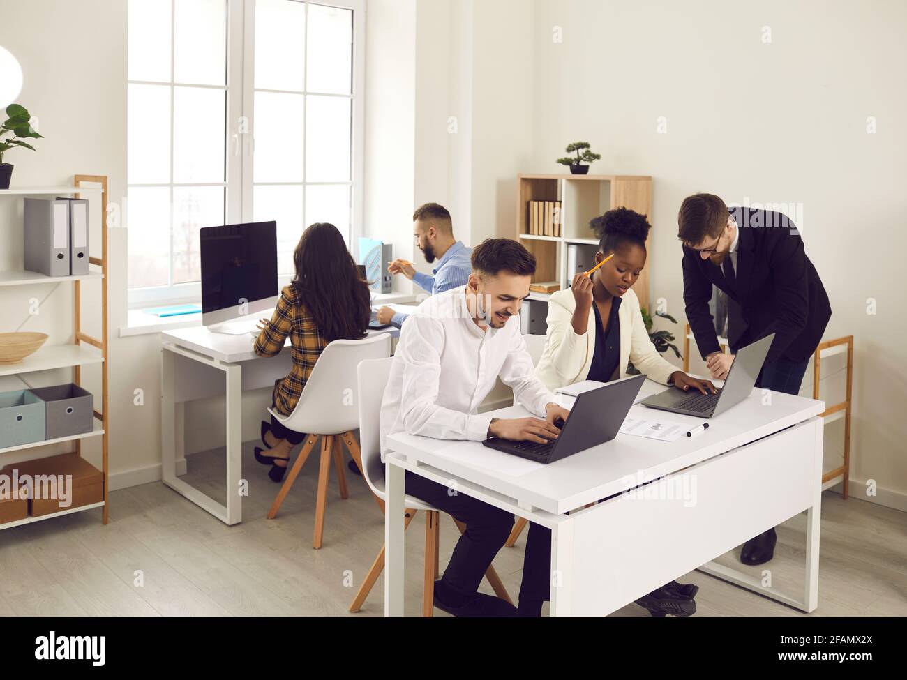 Group of multiethnic business colleagues working together in open space coworking. Stock Photo