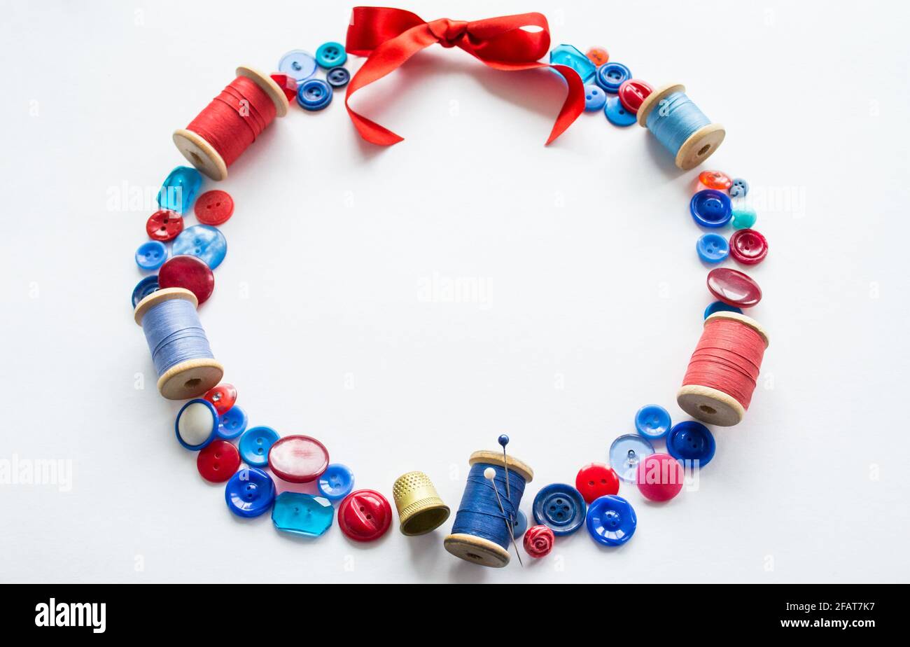 Wreath is made of buttons and threads of red and blue colors with pins