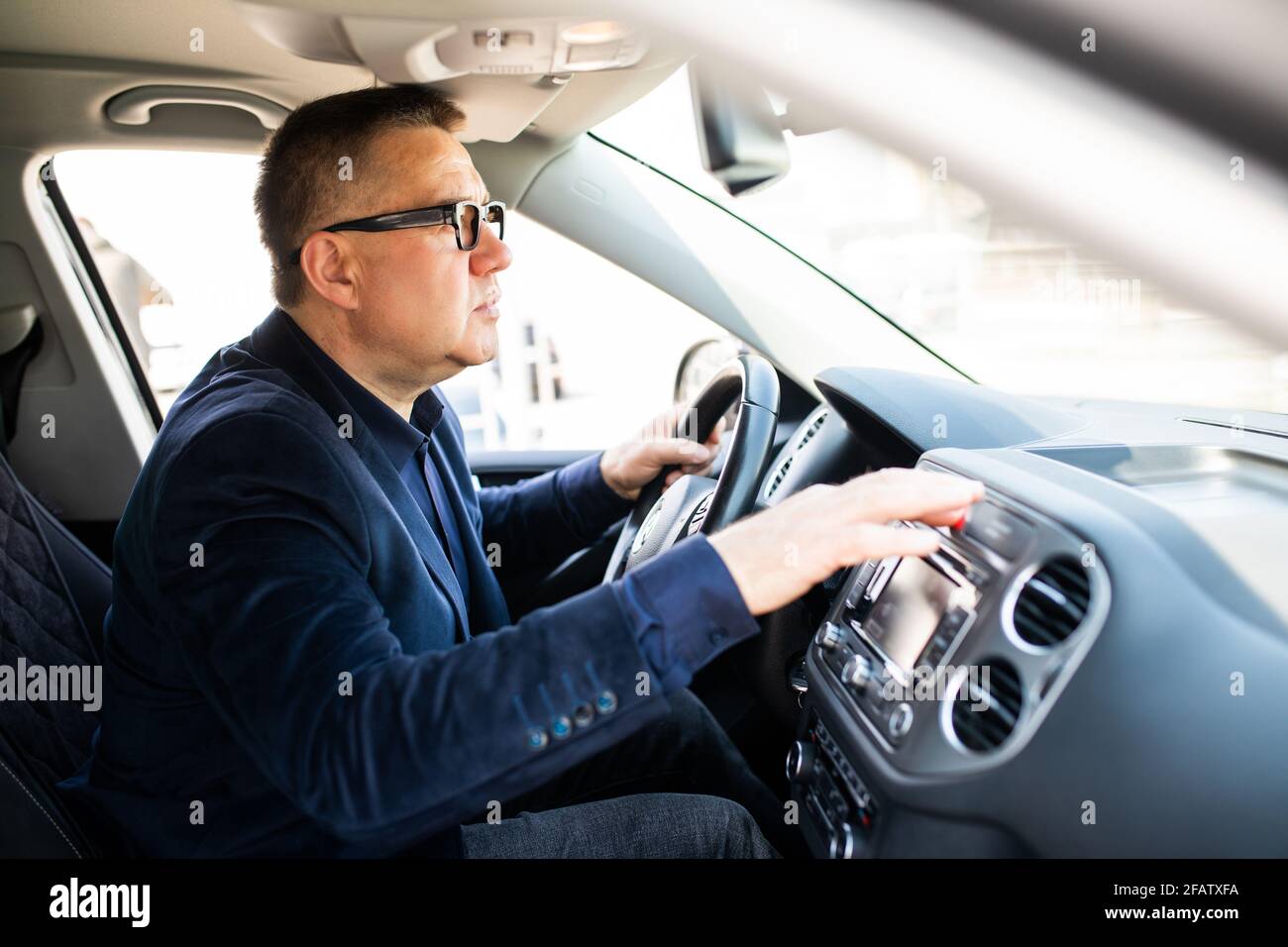 Middle age Man pressing red triangle car hazard warning button Stock Photo