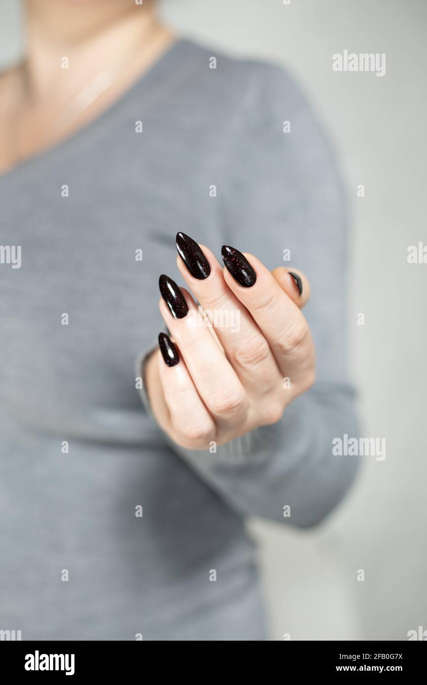 Woman S Hands With Long Nails And Black Manicure With Bottles Of Nail Polish Stock Photo Alamy