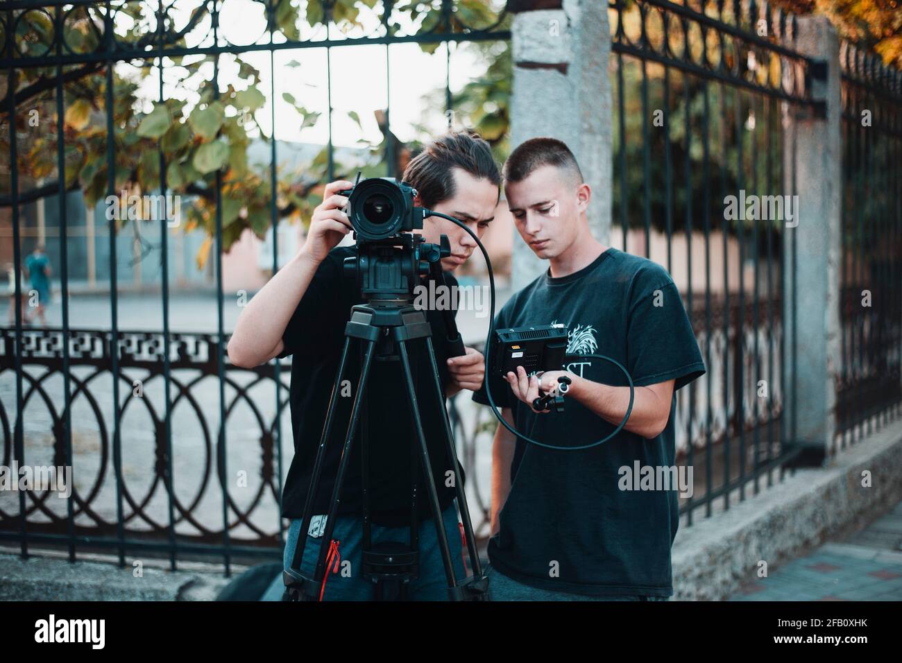 Work of professional filming crew, young operator looks on a screen