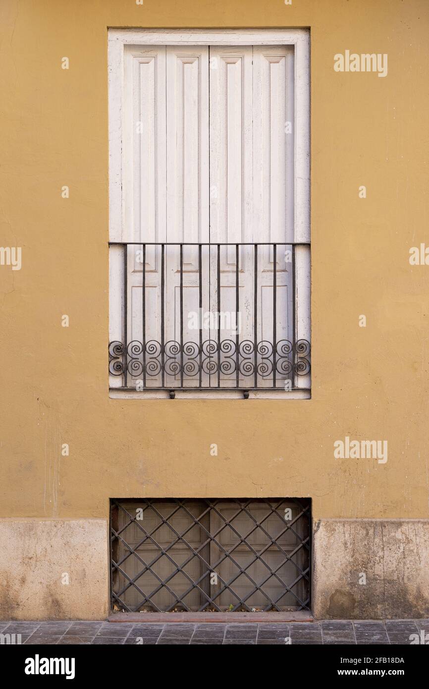 Vintage window with iron grating on a stone wall. Valencia, Spain Stock Photo