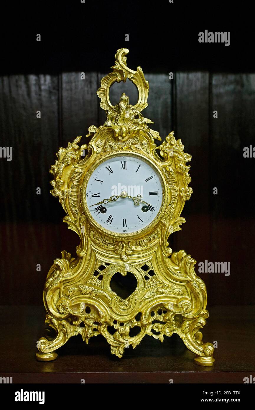Vintage gold desk clock with roman figures on white Porcelain Dial studio shot Mumbai