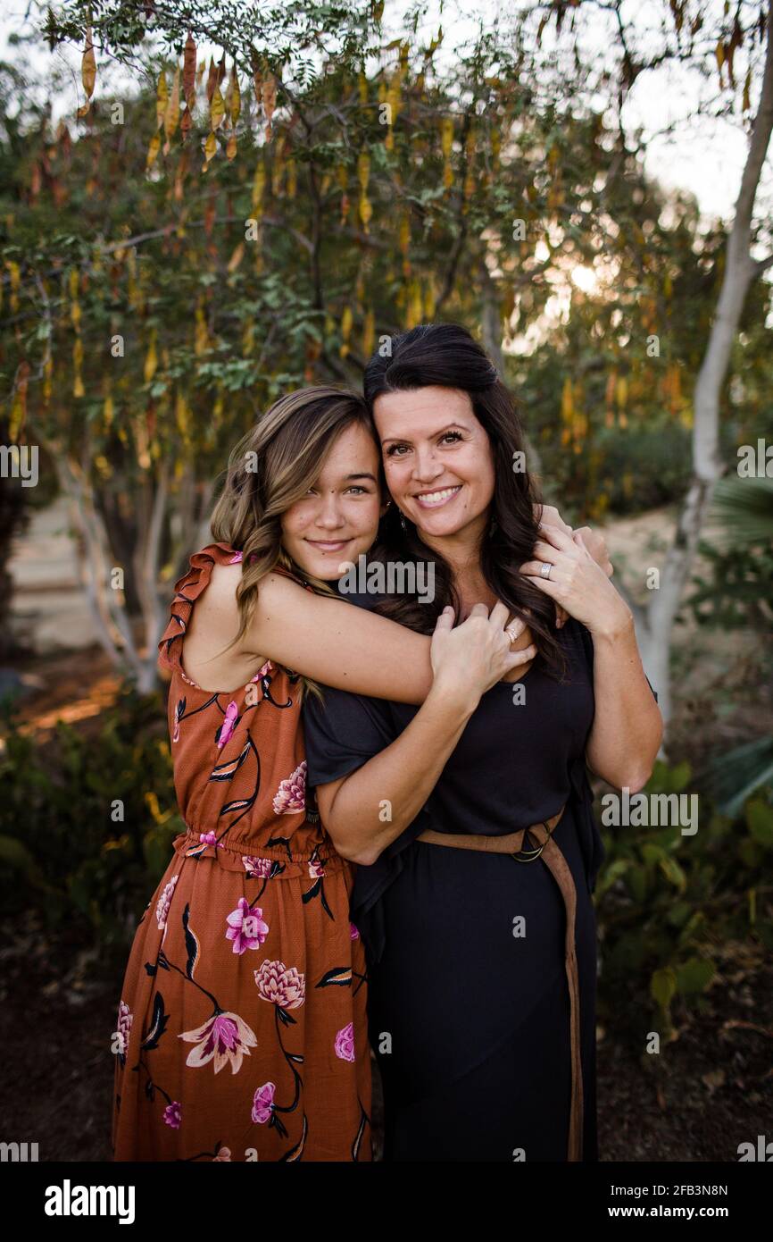Teenage Daughter Embracing Mother in Garden in San Diego Stock Photo