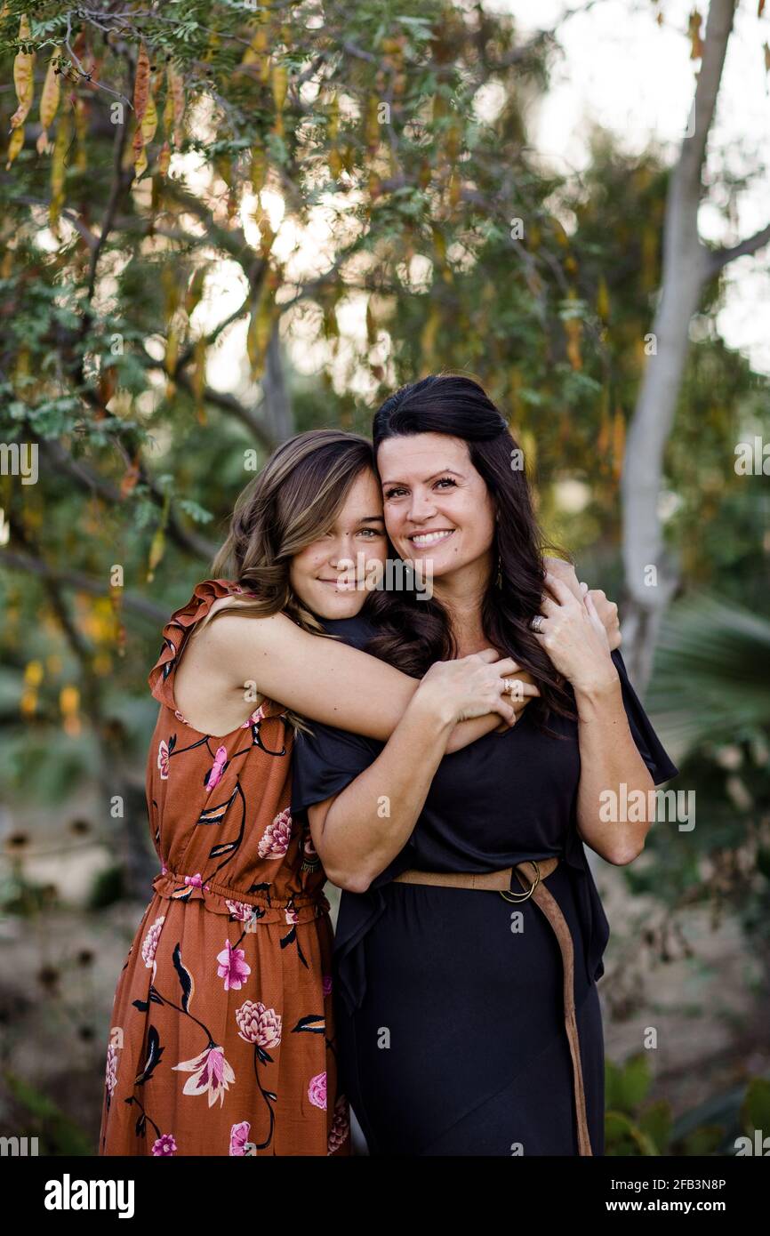 Teenage Daughter Embracing Mother in Garden in San Diego Stock Photo
