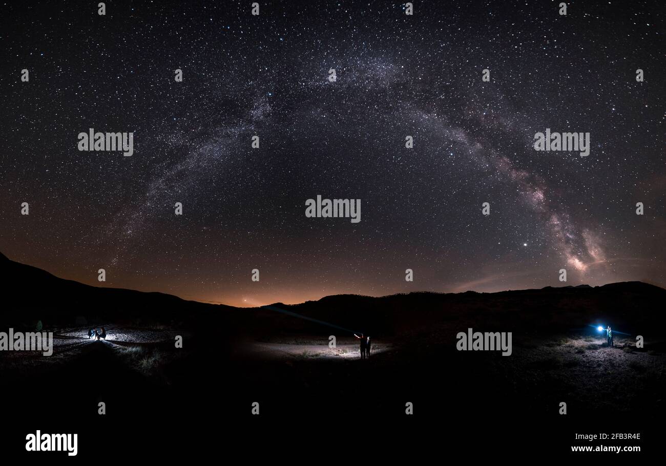 Landscape Milky Way and six people enjoying a night full of stars Stock Photo