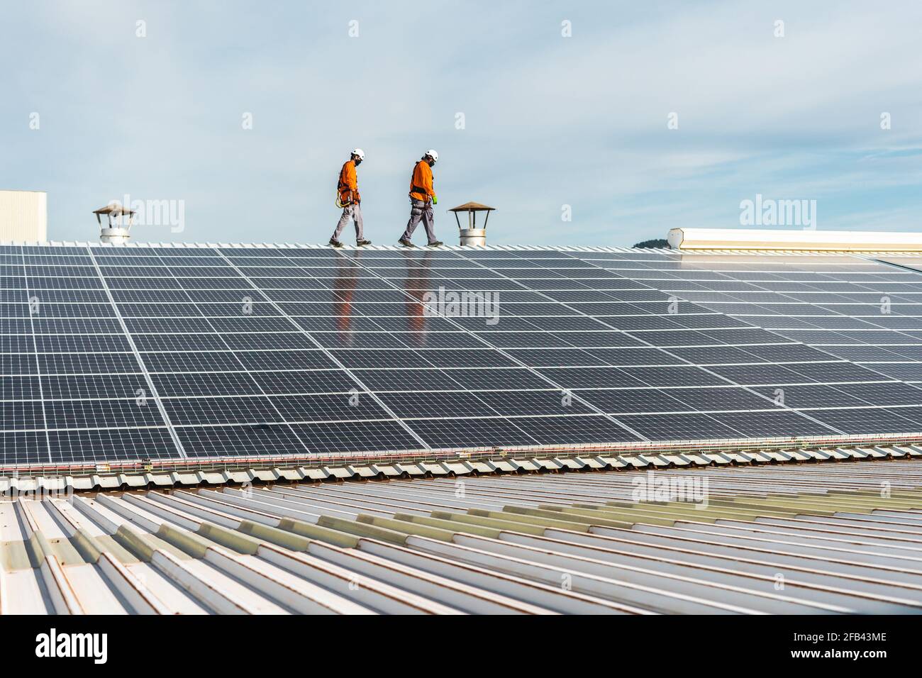 Unrecognizable solar panel technicians walking on a Spanish factoryi ...