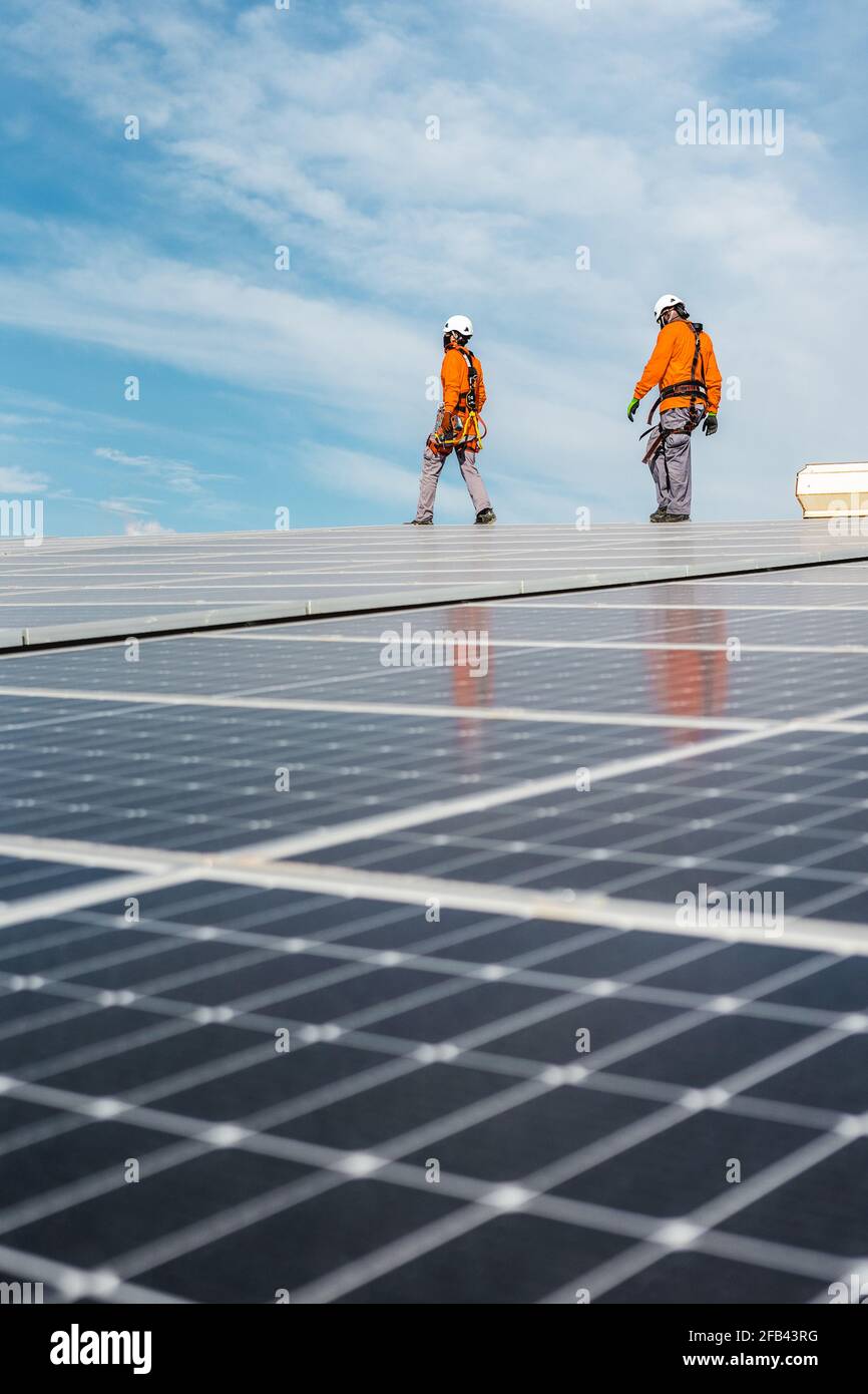 Unrecognizable solar panel technicians walking in Spanish installation Stock Photo