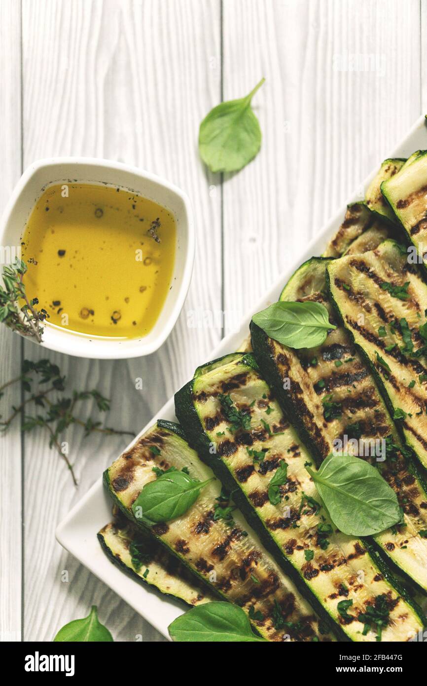 Flat lay and negative space of grilled zucchini with olive oil and basil homemade cooking Stock Photo