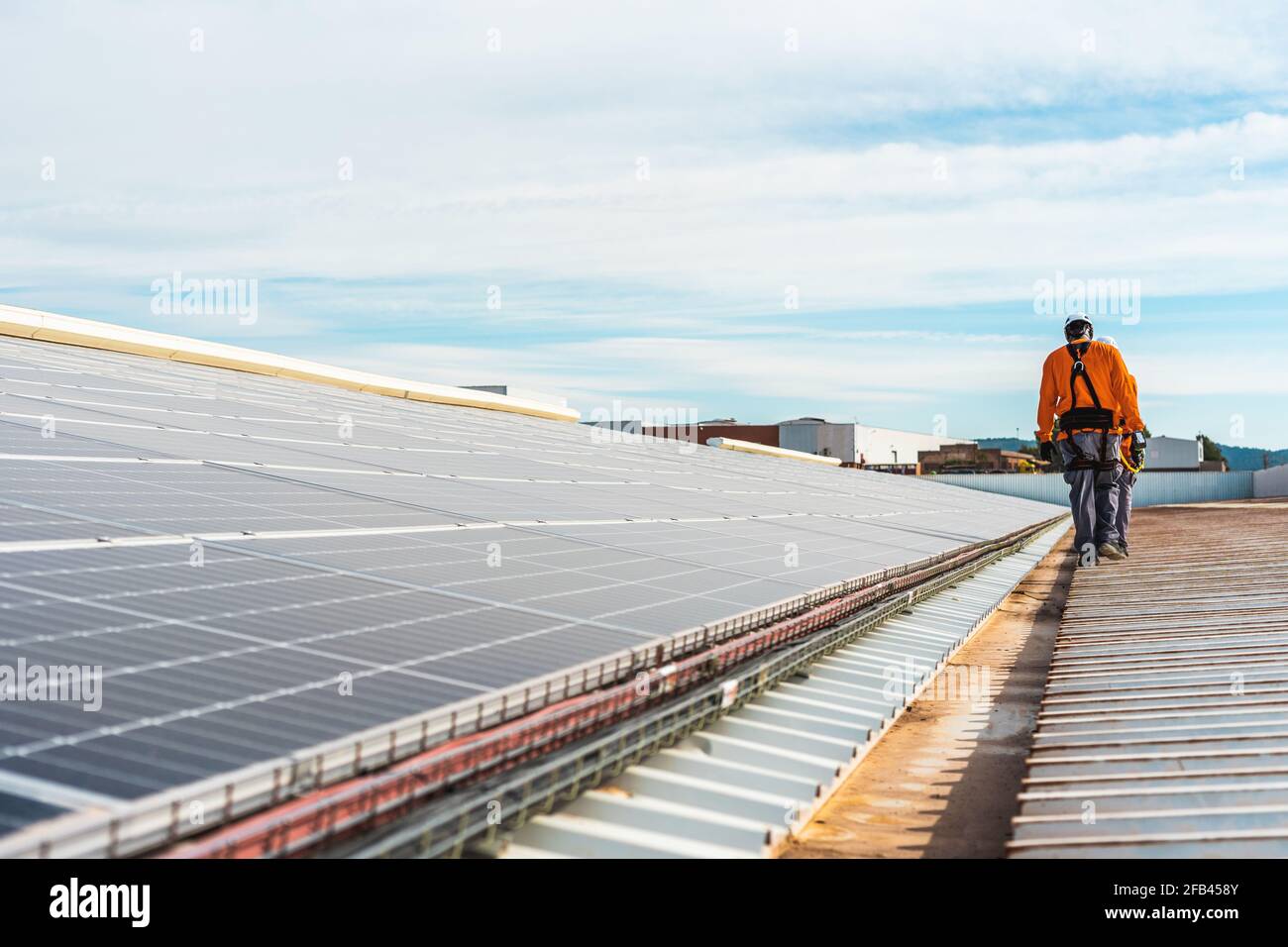 Unrecognizable solar panel technicians walking in Spanish installation Stock Photo