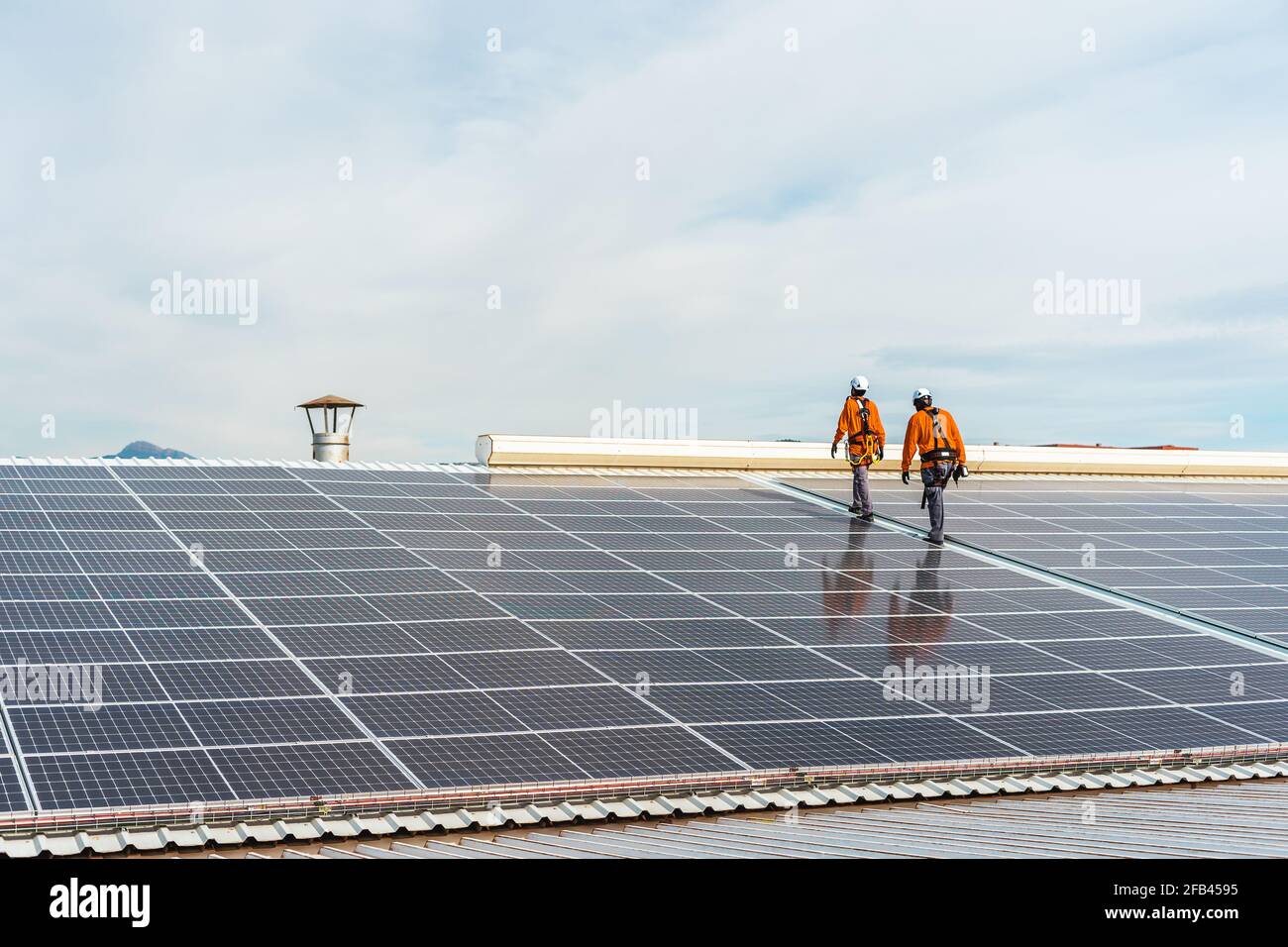 Unrecognizable solar panel technicians walking in Spanish installation Stock Photo