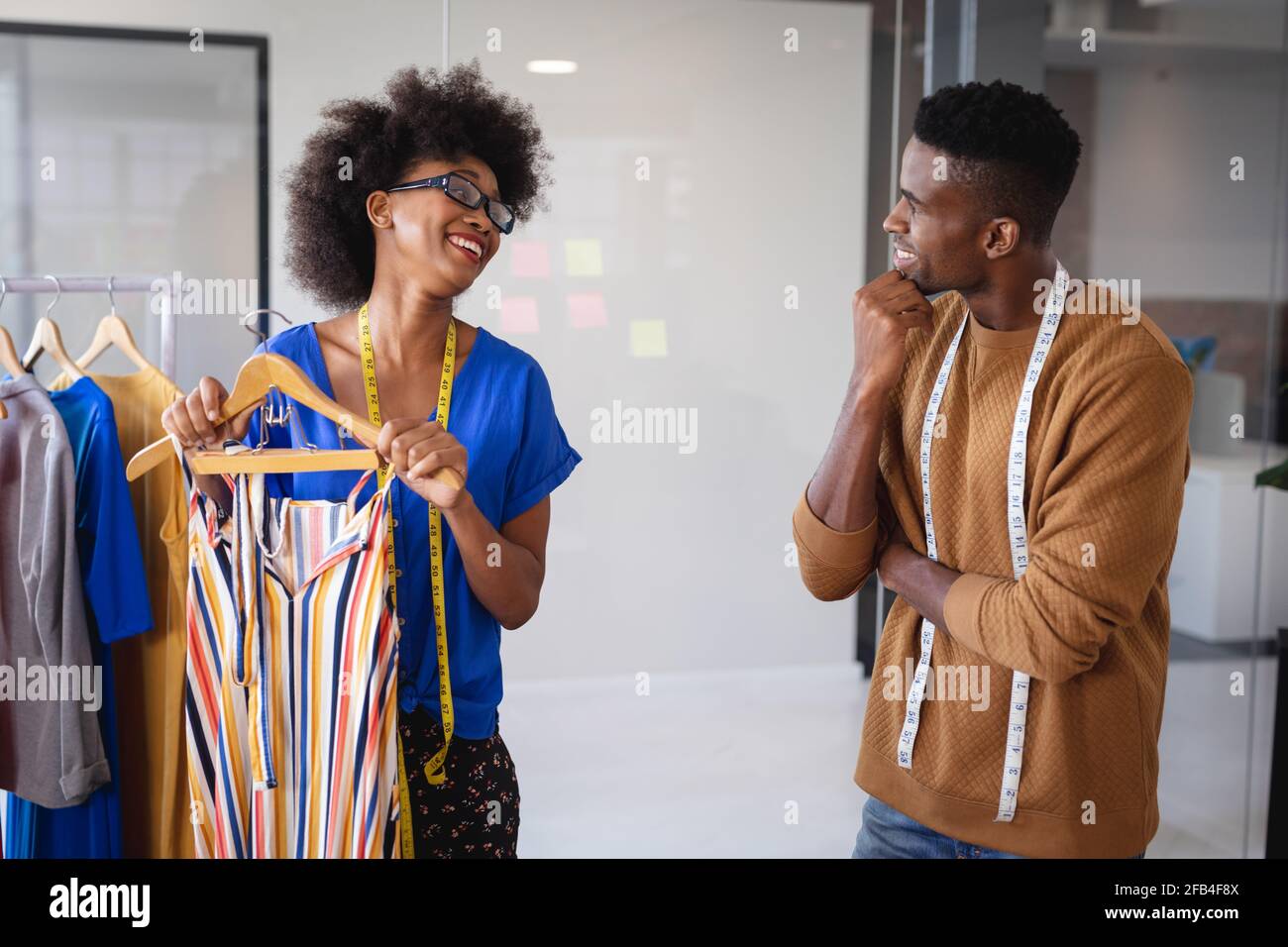 Diverse male and female fashion designers at work discussing and ...