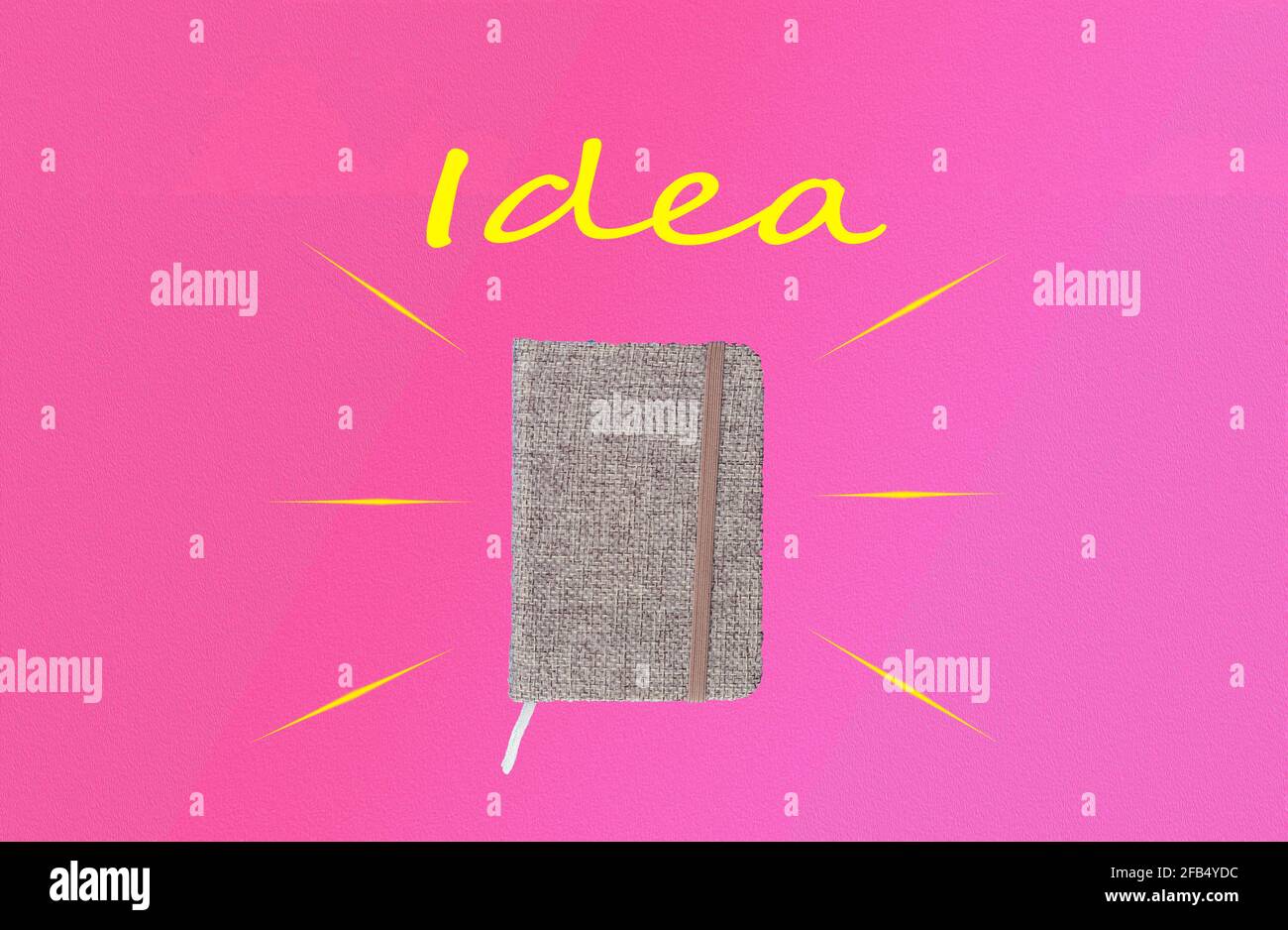 small memo notebook with gray cloth cover on pink background with "idea" lettering on top and copy space Stock Photo