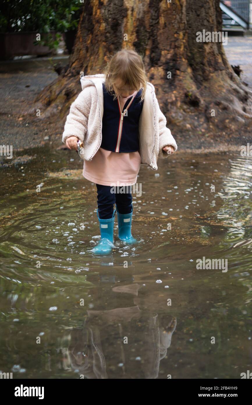 Front view of a girl in rubber boots standing in a puddle Stock Photo ...