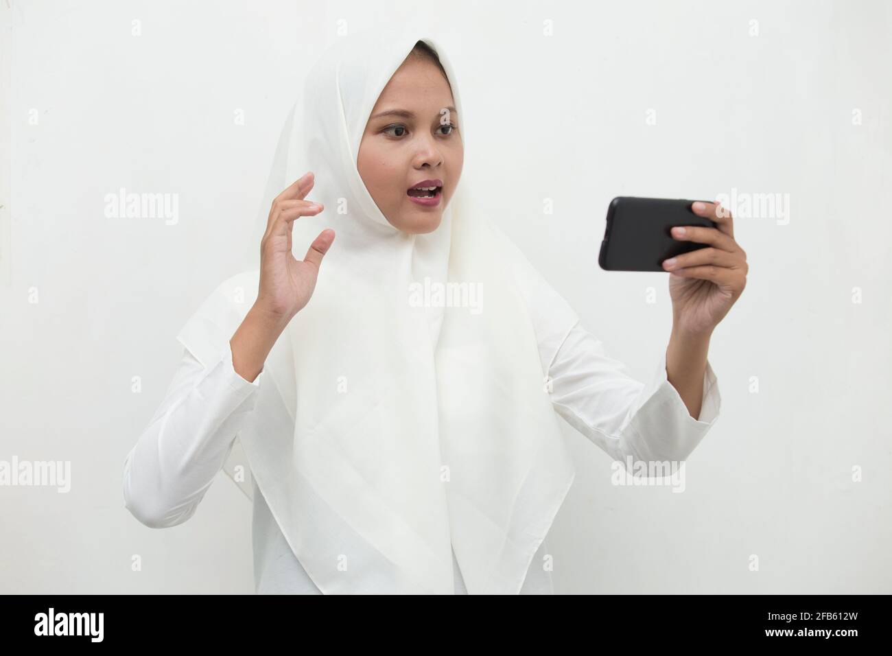 happy young asian muslim woman using mobile phone Stock Photo - Alamy