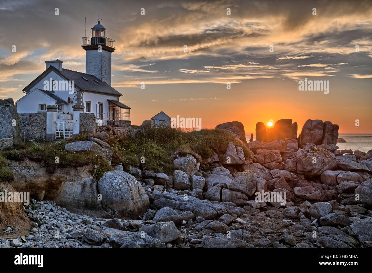 sunset over the Pontusval lighthouse , Brittany France Stock Photo