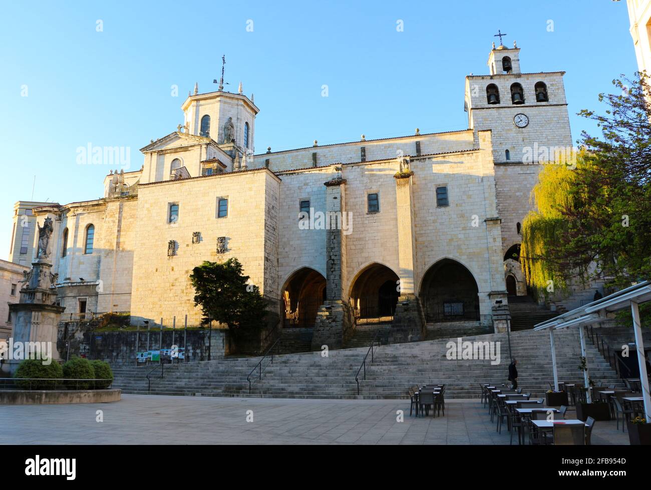 Santander Cathedral from the Plaza Asuncion in the city centre of Santander Cantabria Spain with a statue of the Virgin Mary in front Morning sun Stock Photo