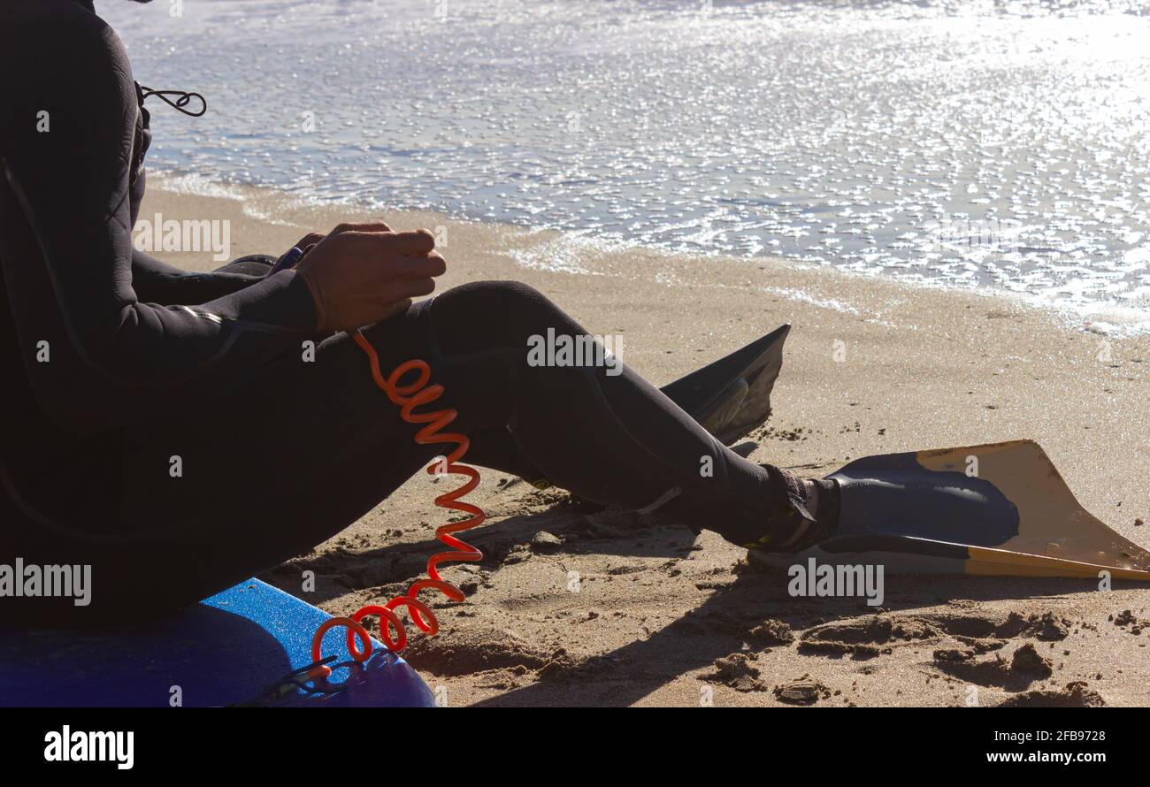 Man preparing to surf on a sunny day. Stock Photo